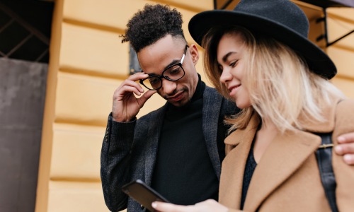 couple walking showing the phone 